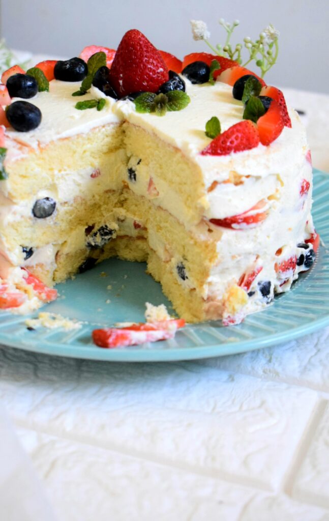 Berry cake with milk cream and blueberry jam on blue ceramic plate isolated  on white background. side view, close up Stock Photo - Alamy